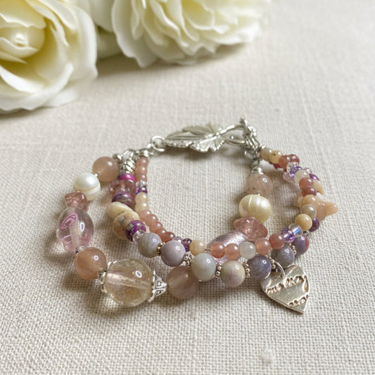 Beaded bracelet with leaf charms on a textured surface