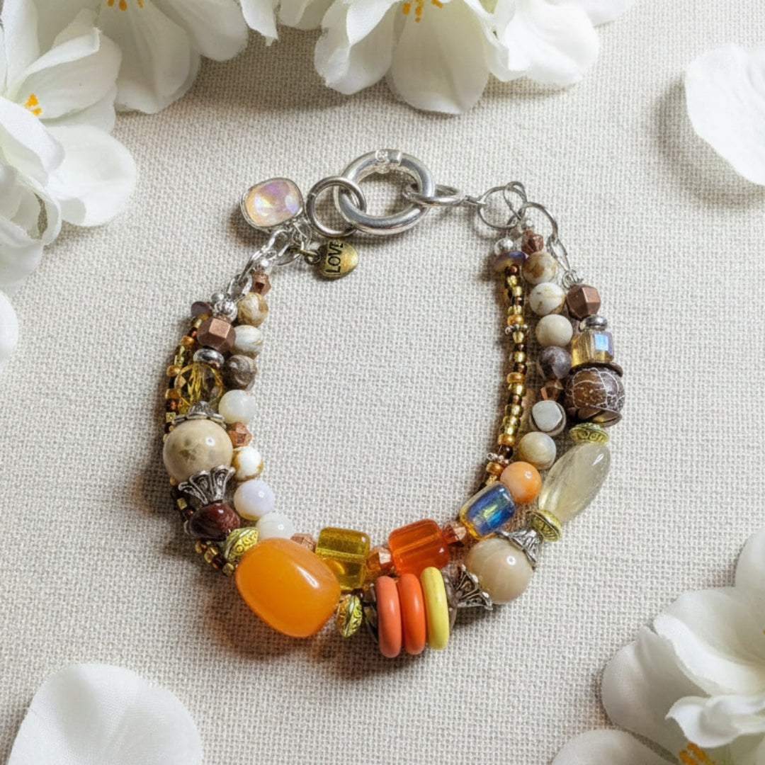 Multi Stone Bracelet on White linen with soft white flowers in the background