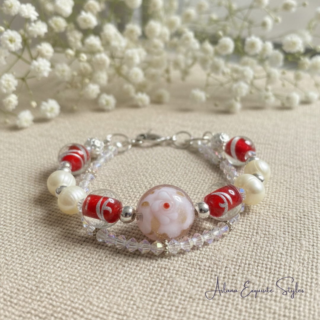 Beaded bracelet with red and white beads on a beige fabric background with white flowers.